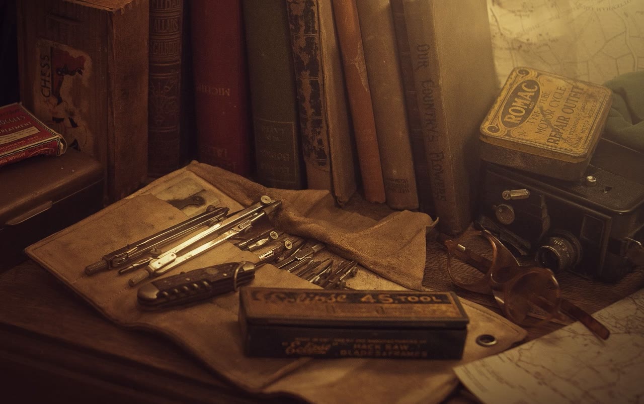 Livres anciens, compas à dessin et vieille carte, dans une lumière chaude.